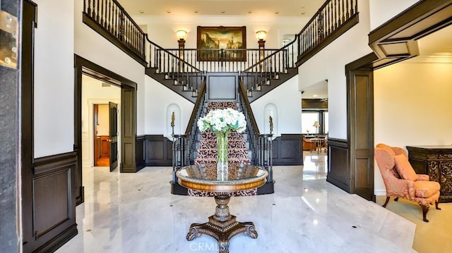 25782 Highplains Ter, Laguna Hills, CA 92653 - foyer entrance featuring a decorative wall, stairway, a towering ceiling, wainscoting, and crown molding