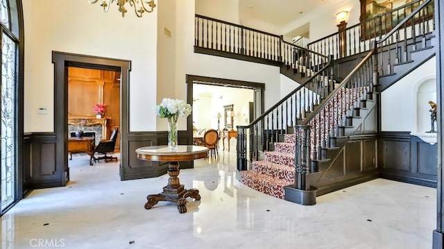 25782 Highplains Ter, Laguna Hills, CA 92653 - stairway featuring a high ceiling, a decorative wall, wainscoting, healthy amount of natural light, and a chandelier