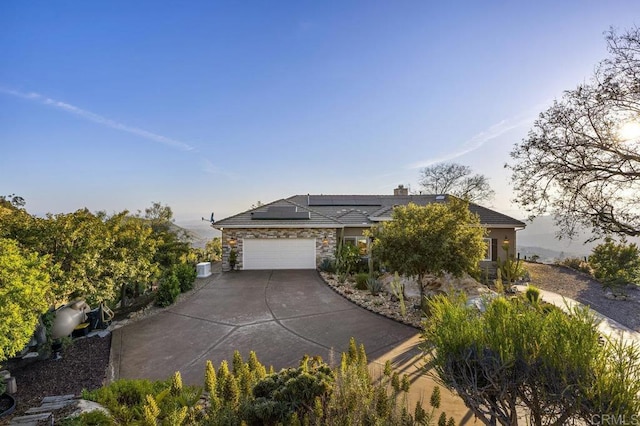 1078 Rainbow Crest Rd, Fallbrook, CA 92028 - view of front of property with stone siding, driveway, roof mounted solar panels, an attached garage, and a chimney