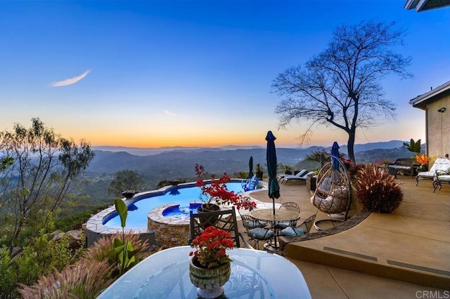 1078 Rainbow Crest Rd, Fallbrook, CA 92028 - pool at dusk featuring outdoor dining area, a patio area, a pool with connected hot tub, and a mountain view