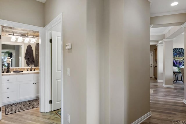 1078 Rainbow Crest Rd, Fallbrook, CA 92028 - corridor featuring crown molding, wood finished floors, baseboards, decorative columns, and a sink