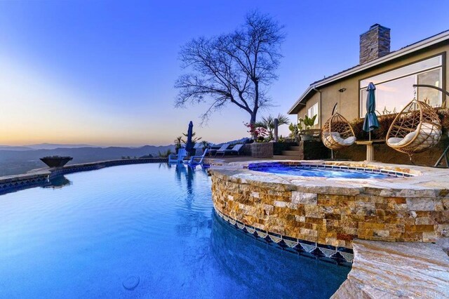 1078 Rainbow Crest Rd, Fallbrook, CA 92028 - pool at dusk featuring an in-ground hot tub and an infinity pool