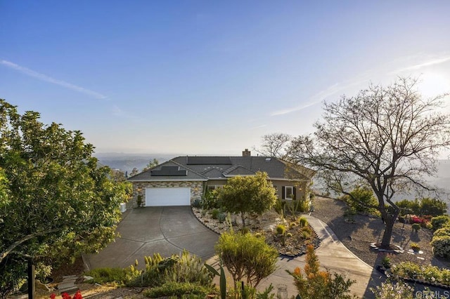 1078 Rainbow Crest Rd, Fallbrook, CA 92028 - view of front facade with concrete driveway, stone siding, a chimney, roof mounted solar panels, and a tile roof