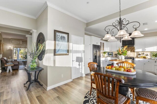 1078 Rainbow Crest Rd, Fallbrook, CA 92028 - dining space with a chandelier, light wood-style flooring, baseboards, and crown molding