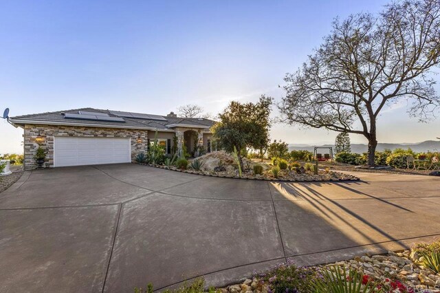 1078 Rainbow Crest Rd, Fallbrook, CA 92028 - view of front of house featuring concrete driveway, stone siding, solar panels, and a garage