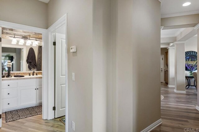 1078 Rainbow Crest Rd, Fallbrook, CA 92028 - hallway with ornamental molding, a sink, wood finished floors, baseboards, and ornate columns