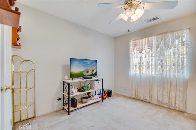 interior space featuring carpet flooring, baseboards, a ceiling fan, and visible vents