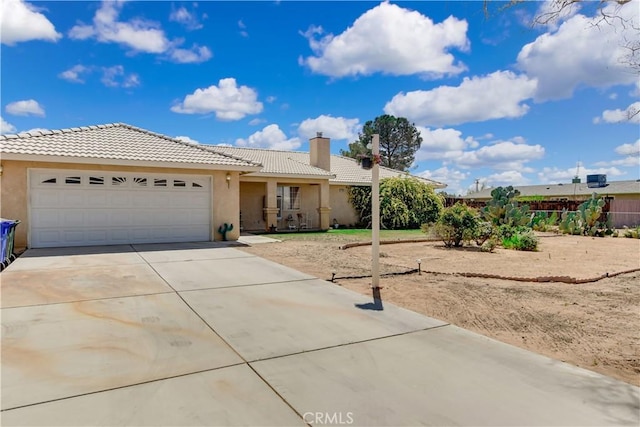 ranch-style home with a garage, driveway, stucco siding, and a tile roof