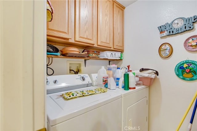 washroom featuring cabinet space and washer and clothes dryer
