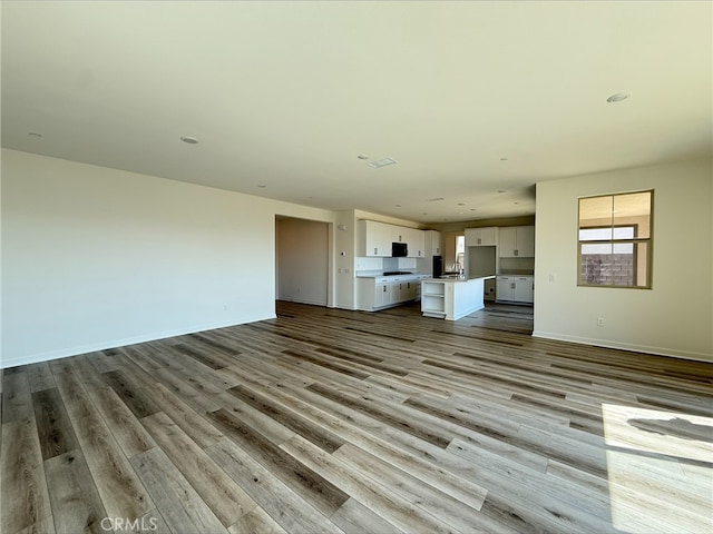 unfurnished living room featuring baseboards and wood finished floors