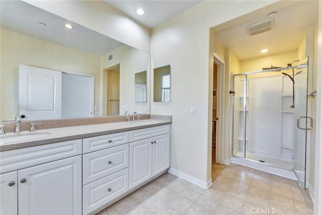 full bathroom featuring a shower stall, baseboards, a sink, and double vanity