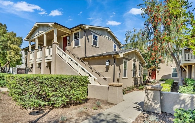 view of front facade featuring stucco siding and stairs