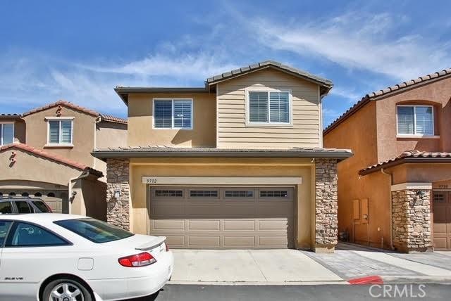 view of front of home with an attached garage, concrete driveway, stucco siding, and stone siding