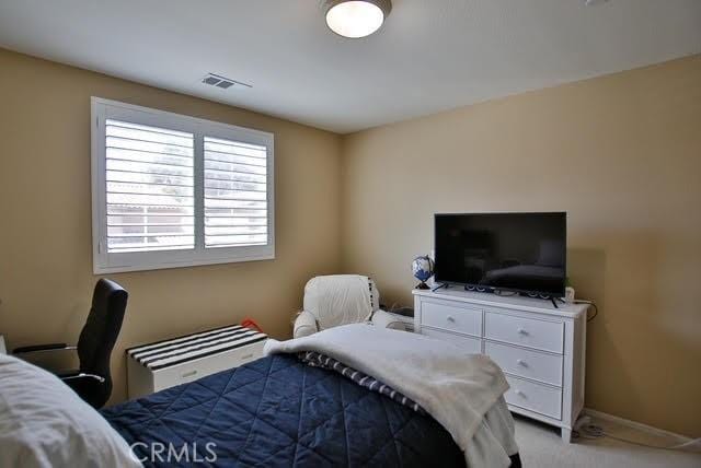 carpeted bedroom with baseboards and visible vents