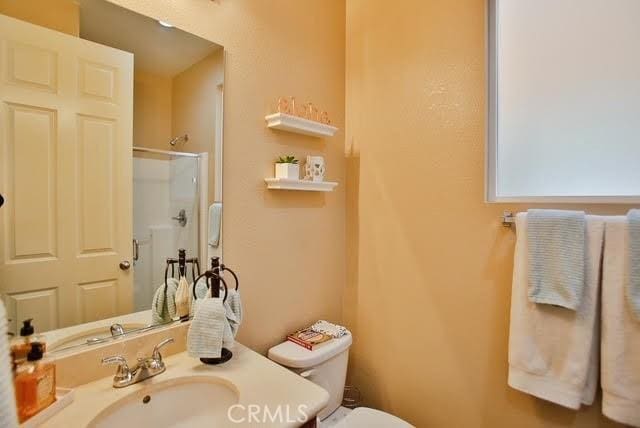 full bath with toilet, a shower with door, and vanity