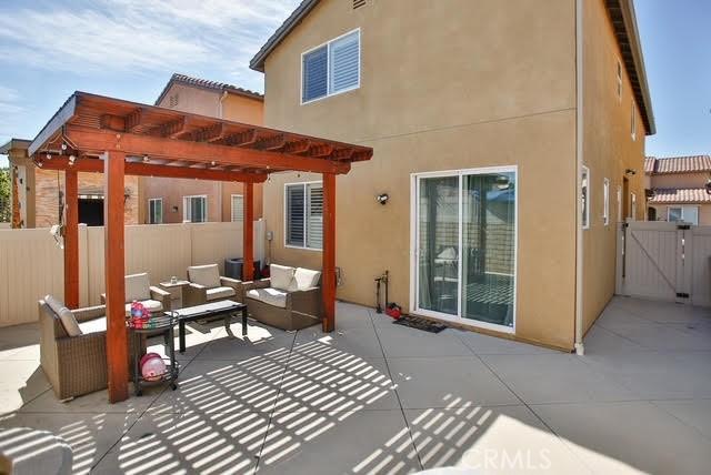 rear view of property with fence, a pergola, an outdoor living space, and a patio