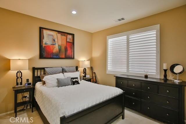bedroom featuring baseboards, light colored carpet, recessed lighting, and visible vents
