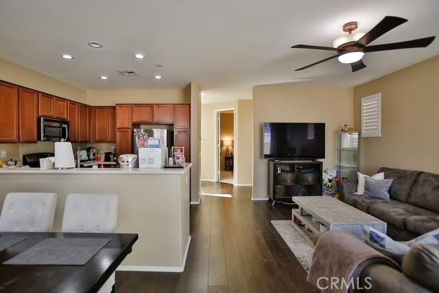 kitchen featuring ceiling fan, appliances with stainless steel finishes, dark wood finished floors, open floor plan, and recessed lighting