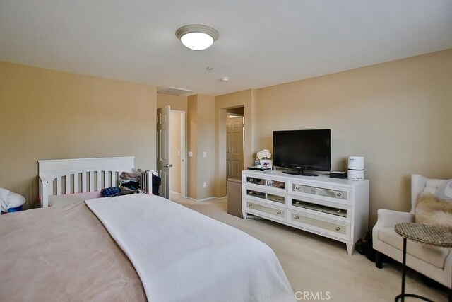 bedroom with visible vents and light carpet