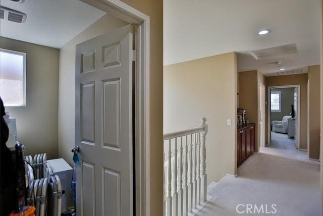 corridor with light colored carpet and visible vents