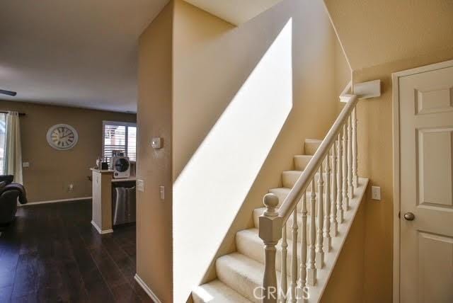 staircase featuring baseboards and wood finished floors