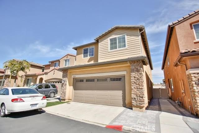 view of front of property featuring a garage, stucco siding, driveway, and stone siding