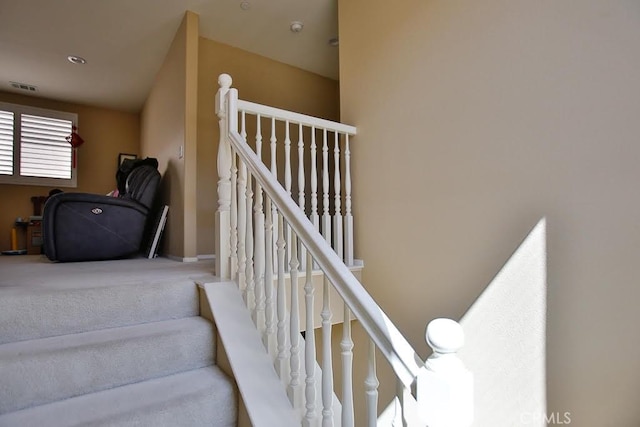 staircase featuring carpet flooring and visible vents
