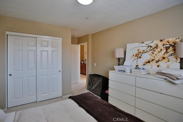 bedroom with light carpet and a closet