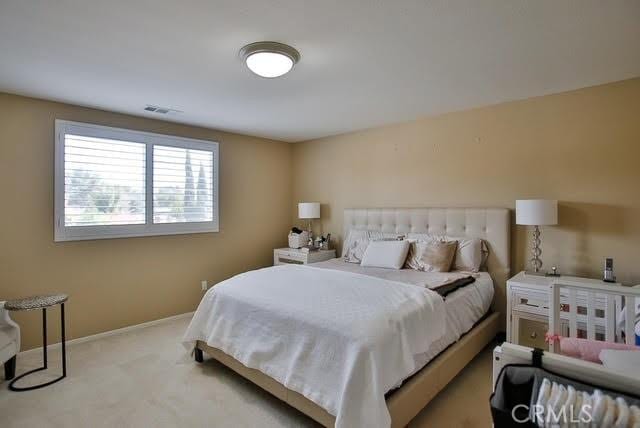 carpeted bedroom with baseboards and visible vents