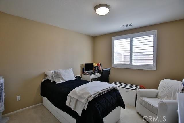 bedroom featuring light colored carpet, baseboards, and visible vents