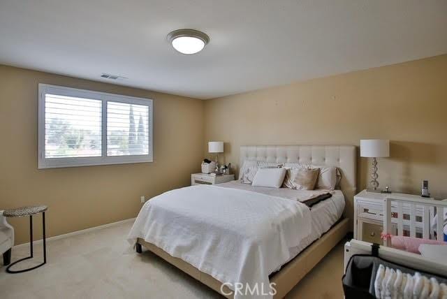 carpeted bedroom featuring baseboards and visible vents