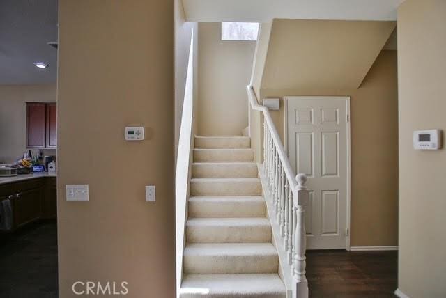 staircase with baseboards, recessed lighting, and wood finished floors
