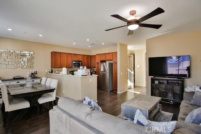 living room with a ceiling fan, recessed lighting, and dark wood-type flooring