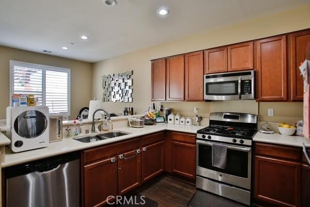 kitchen with light countertops, appliances with stainless steel finishes, and a sink