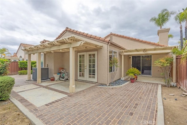 back of property featuring stucco siding, fence, a patio, french doors, and a pergola