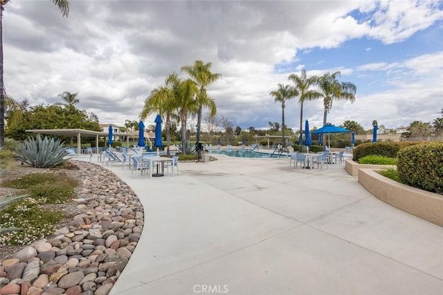 view of home's community with a pool and a patio area