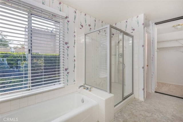 full bathroom featuring a garden tub, a stall shower, and a walk in closet