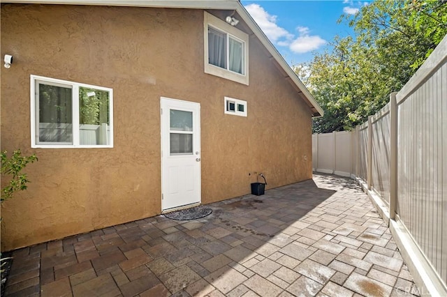 rear view of house featuring a patio area, a fenced backyard, and stucco siding