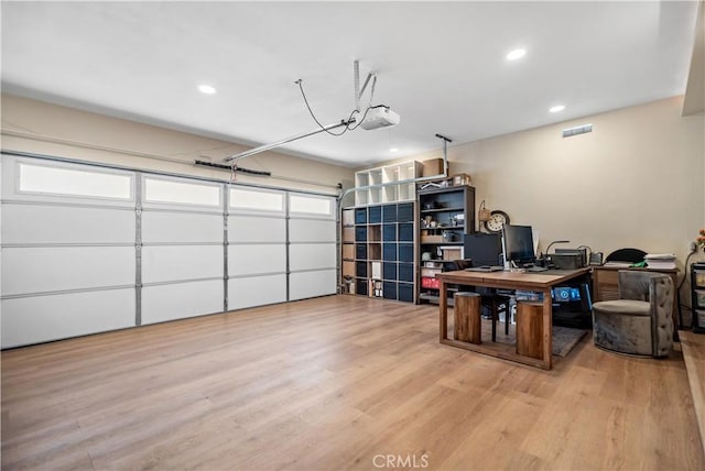 office space with wood finished floors, a garage, visible vents, and recessed lighting