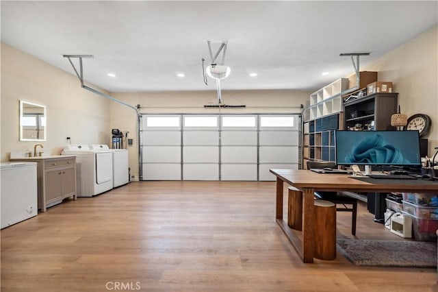 garage with independent washer and dryer, a sink, and recessed lighting