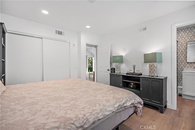 bedroom featuring light wood-style floors, a closet, visible vents, and recessed lighting