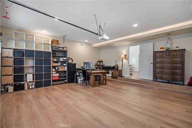 office space with a garage, recessed lighting, and wood finished floors