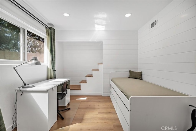 interior space with wood walls, recessed lighting, light wood-style flooring, and visible vents