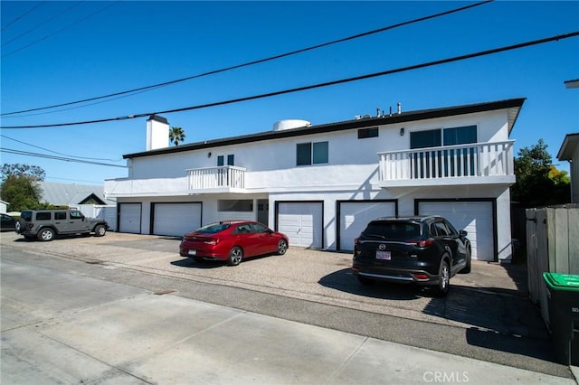 207 Knox St, Costa Mesa, CA 92627 - view of front facade featuring a garage, a balcony, and stucco siding