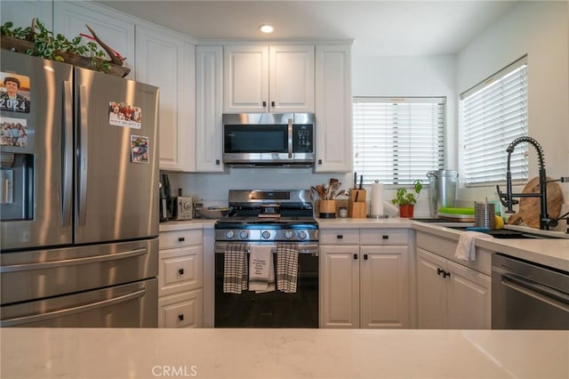 207 Knox St, Costa Mesa, CA 92627 - kitchen featuring recessed lighting, light countertops, white cabinets, stainless steel appliances, and a sink