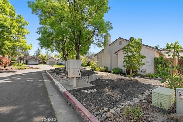 view of property exterior featuring a residential view, a garage, and stucco siding