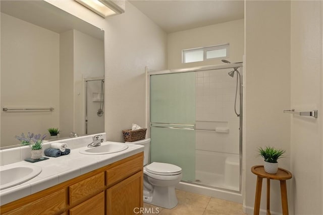 bathroom with toilet, tile patterned floors, a sink, and a stall shower