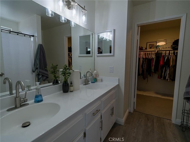 1094 Award Dr, Colton, CA 92324 - full bath with wood finished floors, a spacious closet, double vanity, and baseboards