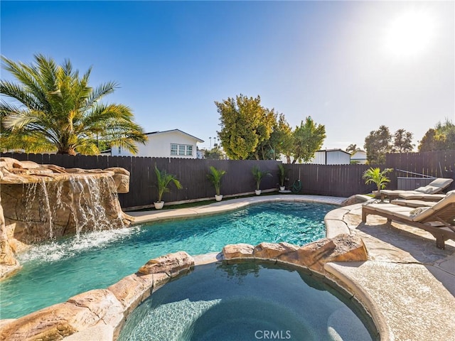 view of pool featuring a fenced backyard and a pool with connected hot tub