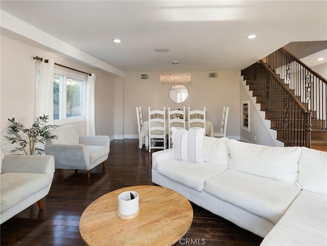living area featuring visible vents, wood-type flooring, and stairs